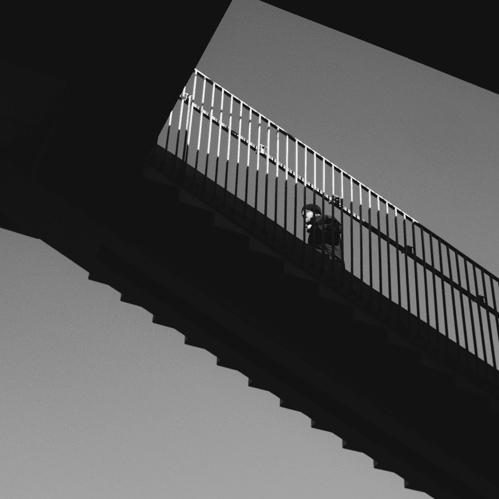 The scene is set outdoors, captured in stark black and white, with a modern architectural element—an overpass—imposing diagonally across the frame.