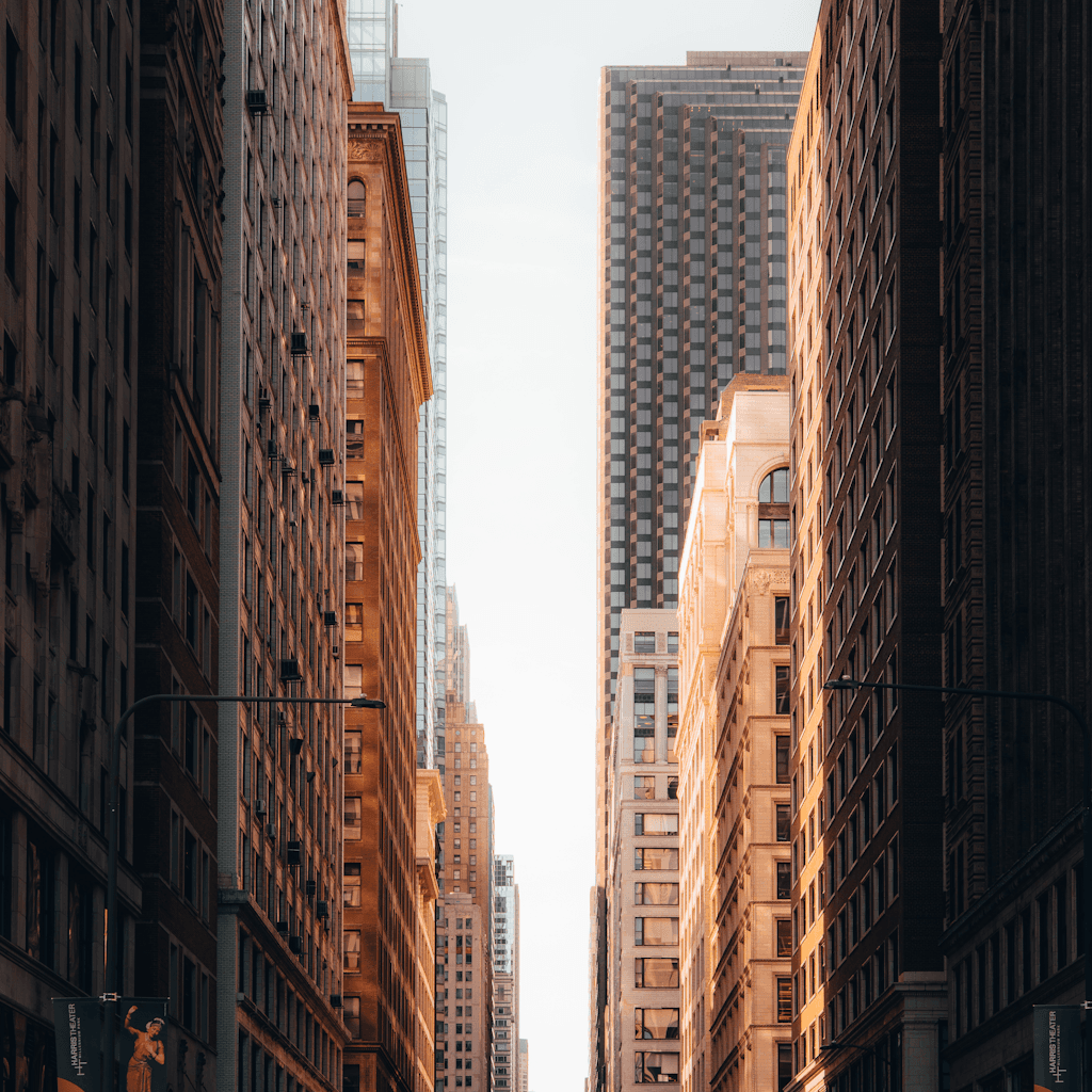 The scene depicts an urban outdoor setting, likely in the late afternoon with a soft golden light permeating the street from the fading sun.